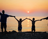 family holding hands at the beach